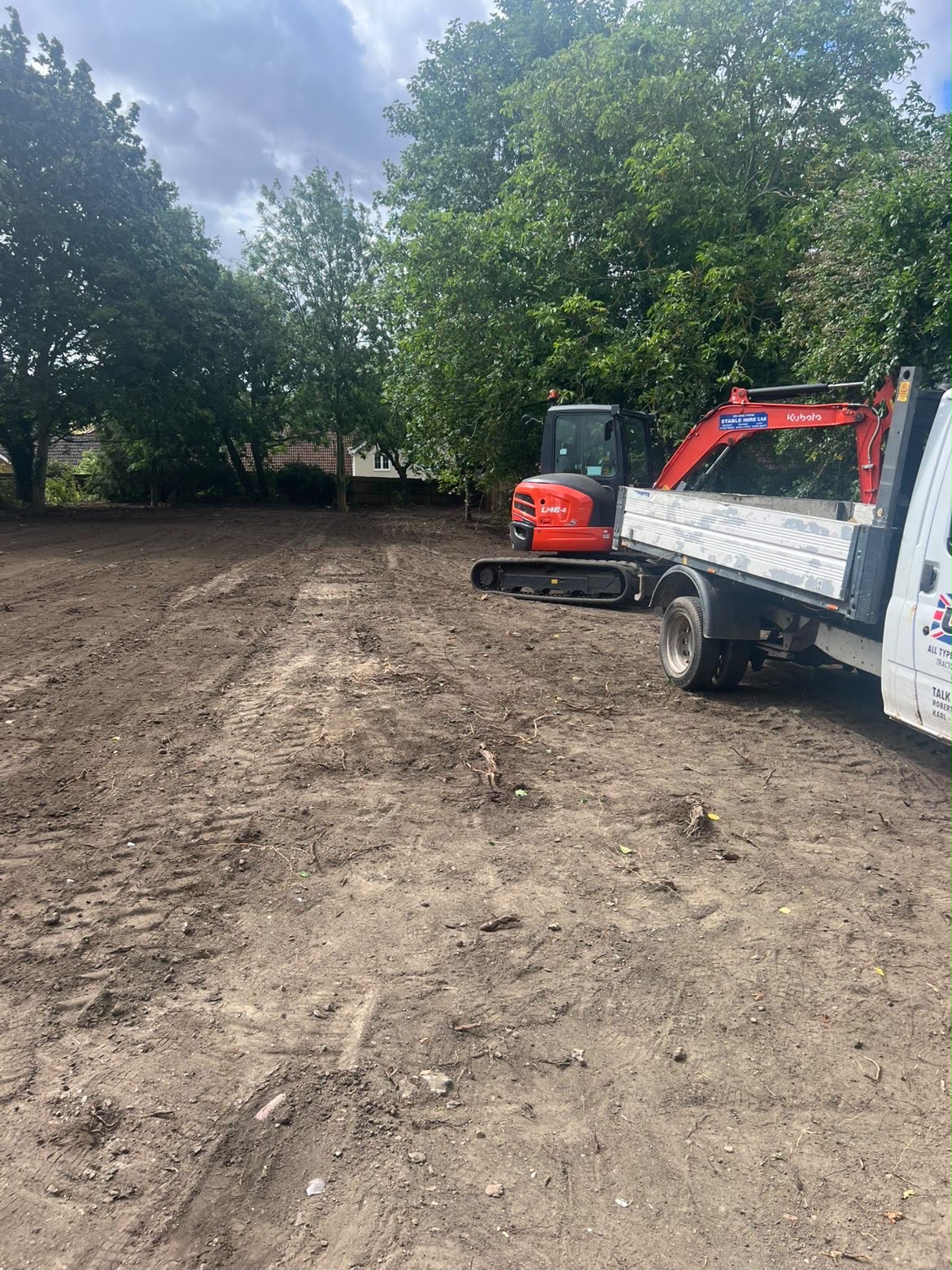 Red excavator and tipper completing site clearance on a Sterling Plant Group groundwork project